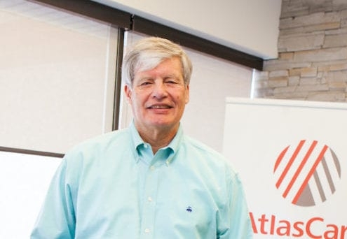 Photo of Roger Grochmal standing in front of an AtlasCare banner