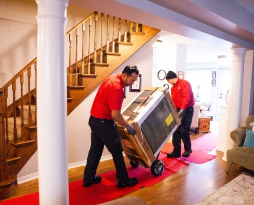 AtlasCare technicians bringing in a furnace through a house