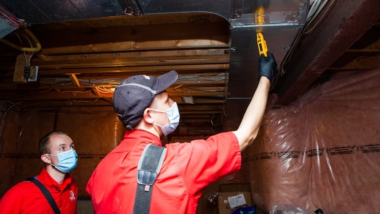 Technicians checking out duct