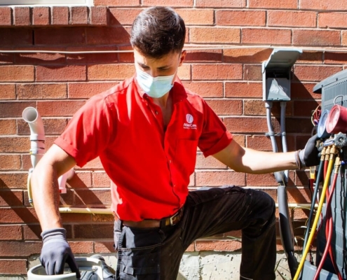 AtlasCare technician working on outdoor air conditioner unit