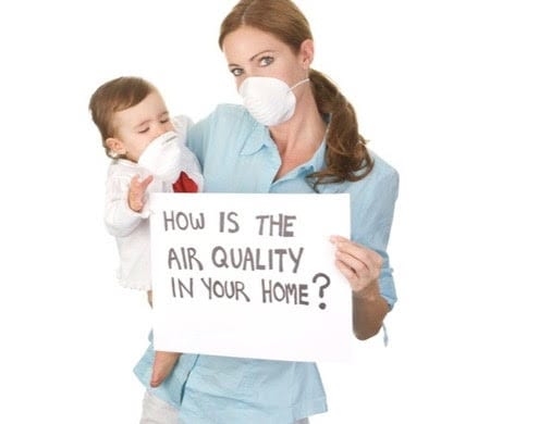 Woman and child wearing a face mask and holding an air quality sign