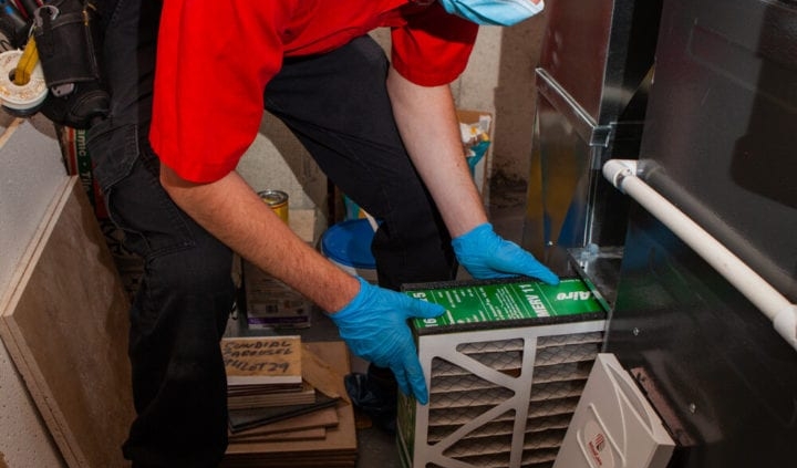 HVAC technician removing a dirty air filter
